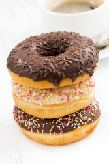 glazed donuts on a plate and cup of coffee, closeup