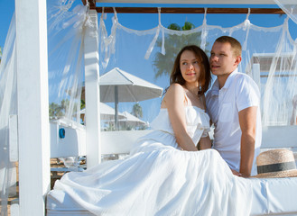 Happy man and woman sitting under a  baldachin © zest_marina