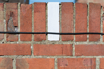 Brick on wall painted white to mark boundary for car parking space