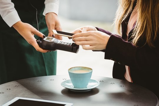 Woman paying with mobile phone