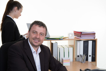 Mid age business man working  with a woman in a background