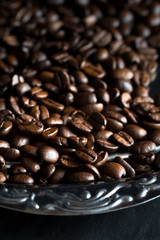 Kaffeebohnen liegen auf einer silbernen Servierplatte
