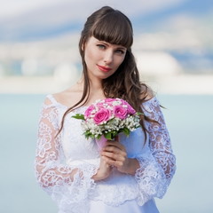 brunette bride sea background with  bouquet