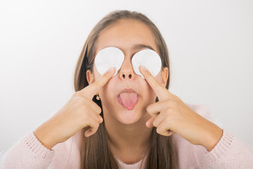 Teen girl holds cotton pads near the face. teen cleansing, beautiful girl holding a cotton ball near the face. skin cleansing
