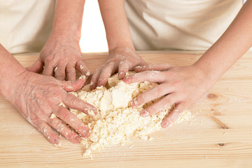 the grandmother and the granddaughter knead dough