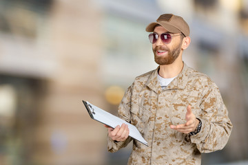 Portrait of young army soldier with a laptop