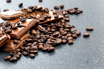 Chocolate pieces and coffee beans on a stone table