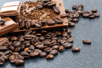 Chocolate pieces and coffee beans on a stone table