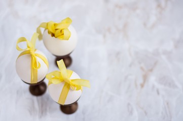 uova bianche nel portauovo legate con nastri gialli © faustalavagna