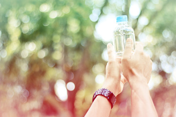 Stock Photo:.Man holding a bottle of water at park, health care,