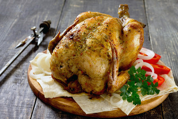 Grilled chicken with various vegetables and spices on the old wo