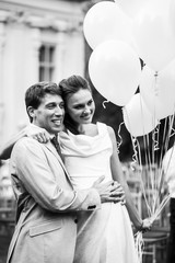 Happy smiling bride and groom holding yellow balloons background