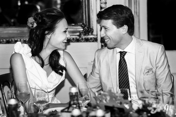 happy bride and groom smiling  look et each other in a restauran