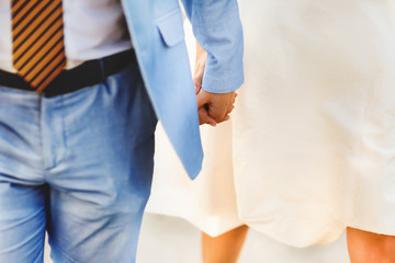 Obraz na płótnie Canvas groom in blue suit holding a bride in a white dress