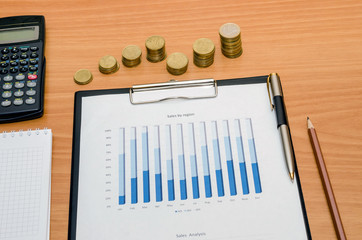 business diagram with coins, pen and calculator on table
