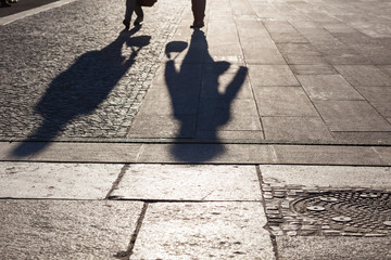 Stadtleben Symbolbild, Schatten von Menschen auf Strasse