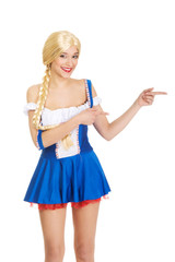 Woman in Bavarian dress pointing aside.