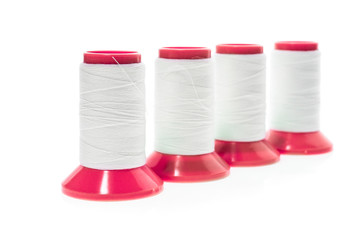 Professional sewing threads on a red industrial roll.