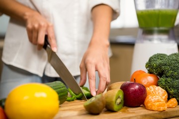 Close up of woman slicing vegetables for smoothie