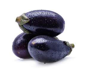 Raw eggplants with water drops on white background.