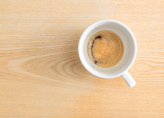 Time for espresso.Half espresso coffee in a cup on wooden textured table 