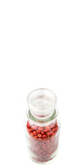 Pink peppercorns in vial glass over white background