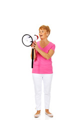 Senior smiling woman screaming through a megaphone