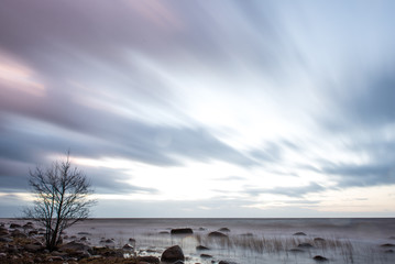 Sunset at the sea shore of a beach with rocks