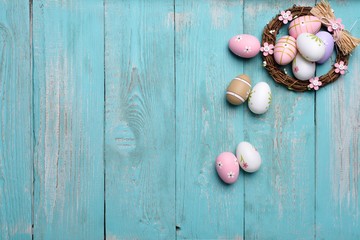 Easter eggs in nest on wooden background.