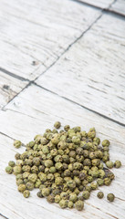 Dried green peppercorn wooden background