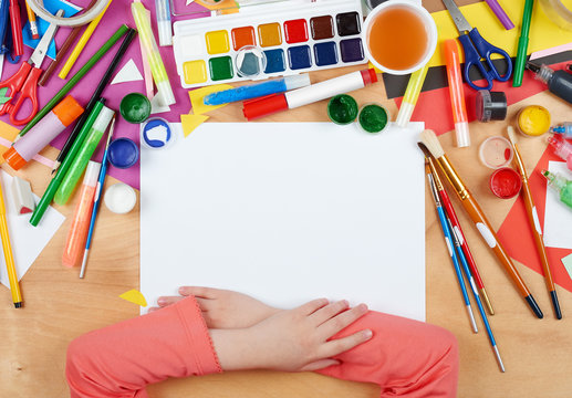 Child drawing top view. Artwork workplace with creative accessories. Flat lay art tools for painting.