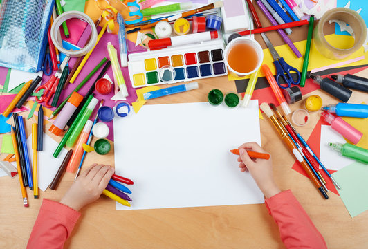 Child drawing top view. Artwork workplace with creative accessories. Flat lay art tools for painting.