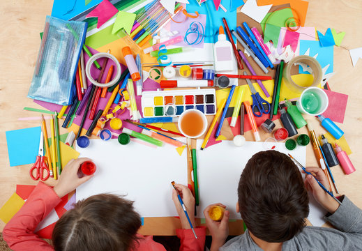 Child drawing top view. Artwork workplace with creative accessories. Flat lay art tools for painting.