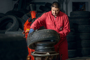 Close up of mechanic inflating tire on wheel in workshop 