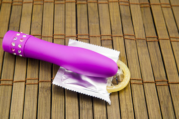 vibrator and condom on a wooden background