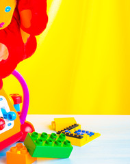 Obraz premium Children multicolored toys on bright yellow background