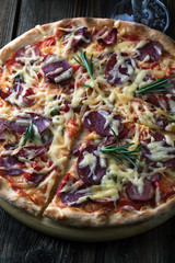 Delicious pizza with salami, tomatoes