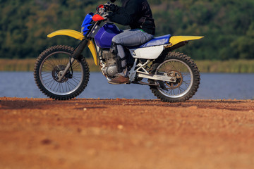Obraz na płótnie Canvas man riding enduro motorcycle on dirt field
