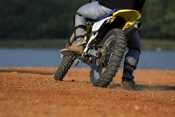 Gordijnen man riding enduro motorcycle on dirt field © stockphoto mania