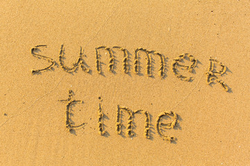 Fototapeta premium Summer time - text written on sandy beach.