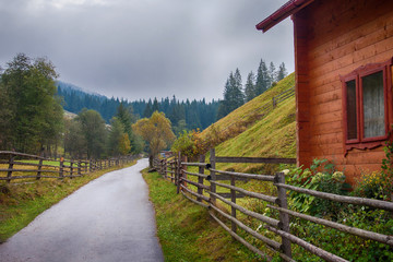 Landscape with hills, house and wooden fence. Ukrainian Carpathians