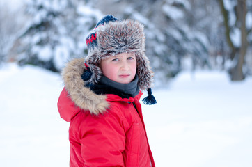 Fototapeta na wymiar Boy in a red jacket in the winter forest