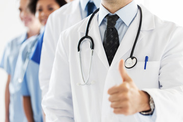 close up of happy doctor showing thumbs 