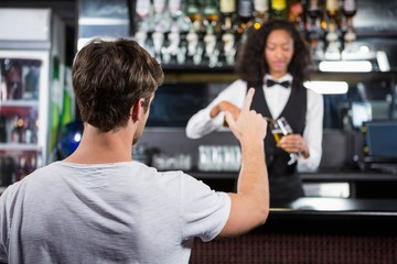 Man ordering a drink at bar counter