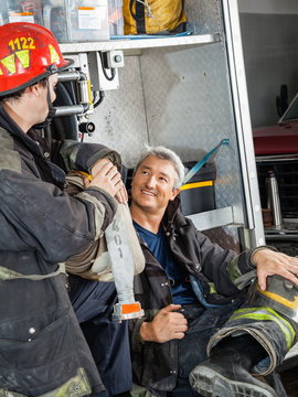 Firefighter Discussing With Colleague On Truck