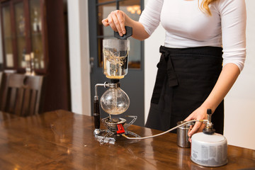 close up of woman with siphon coffee maker and pot