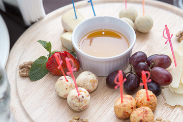 Different types of cheese balls, served with sauce and grapes on