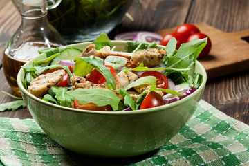 Fresh salad with chicken, tomatoes and arugula on plate