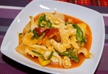 Close up stir fried squid with salted egg yolk on white dish.