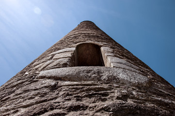 Irland, County Wicklow, Glendalough, Kloster: Detail vom ber&uuml;hmten irischen Rundturm von unten mit blauem Himmel im Hintergrund. 